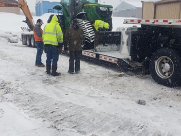 Groomer loaded onto tractor trailer for hauling to repair shop